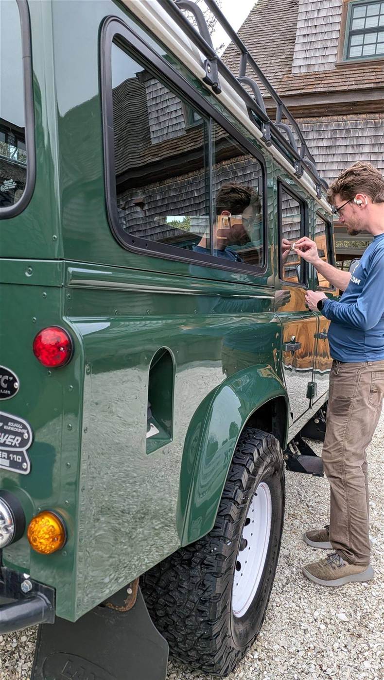 ACK technician hand-detailing a classic Land Rover Defender on Nantucket