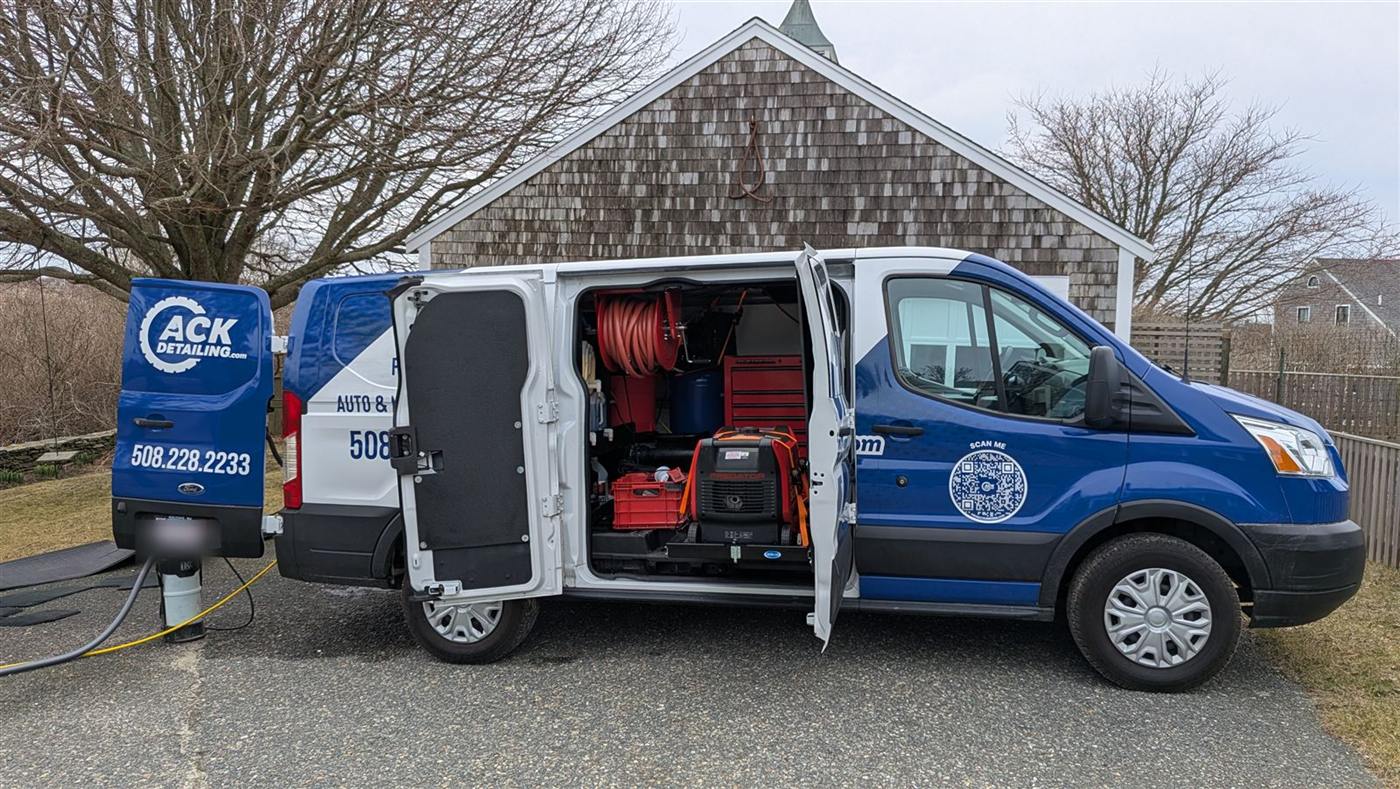 ACK Detailing van on a job — doors open with hose reel, water, and generator on board